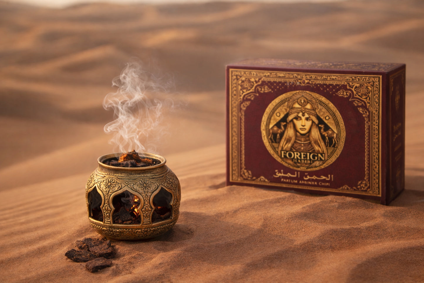 Gold bakhoor burner with Foreign Habibi incense chips burning and smoke rising over desert sand.